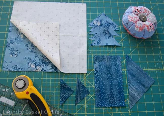 Lets start by cutting Dark Triangles and Tree Trunk pieces from blue fabric as shown in the directions on page 94, when nished we should