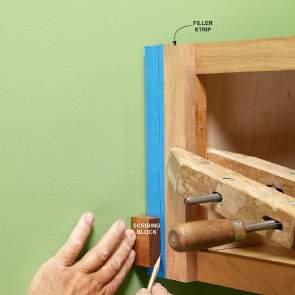 Use a Block of Wood for Scribing Find the largest distance between the outside of the cabinet and the wall.