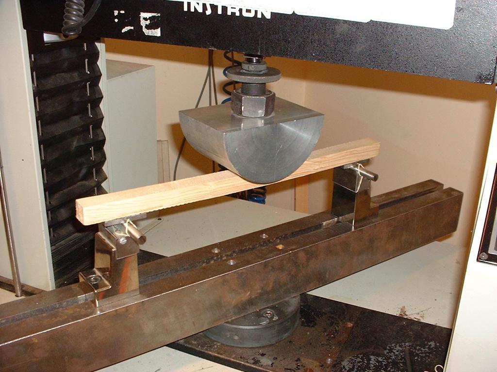 Pivotal bearing plates supported both ends of the sample to permit adjustment for slight twists in the specimen. The load was applied continuously throughout the test at a crosshead rate of 0.