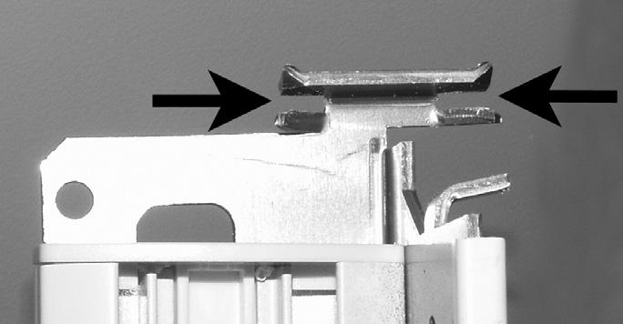 Install the stationary rail. The stationary rail bracket has two slots at the top. The back tracks of the headrail fit into these slots.