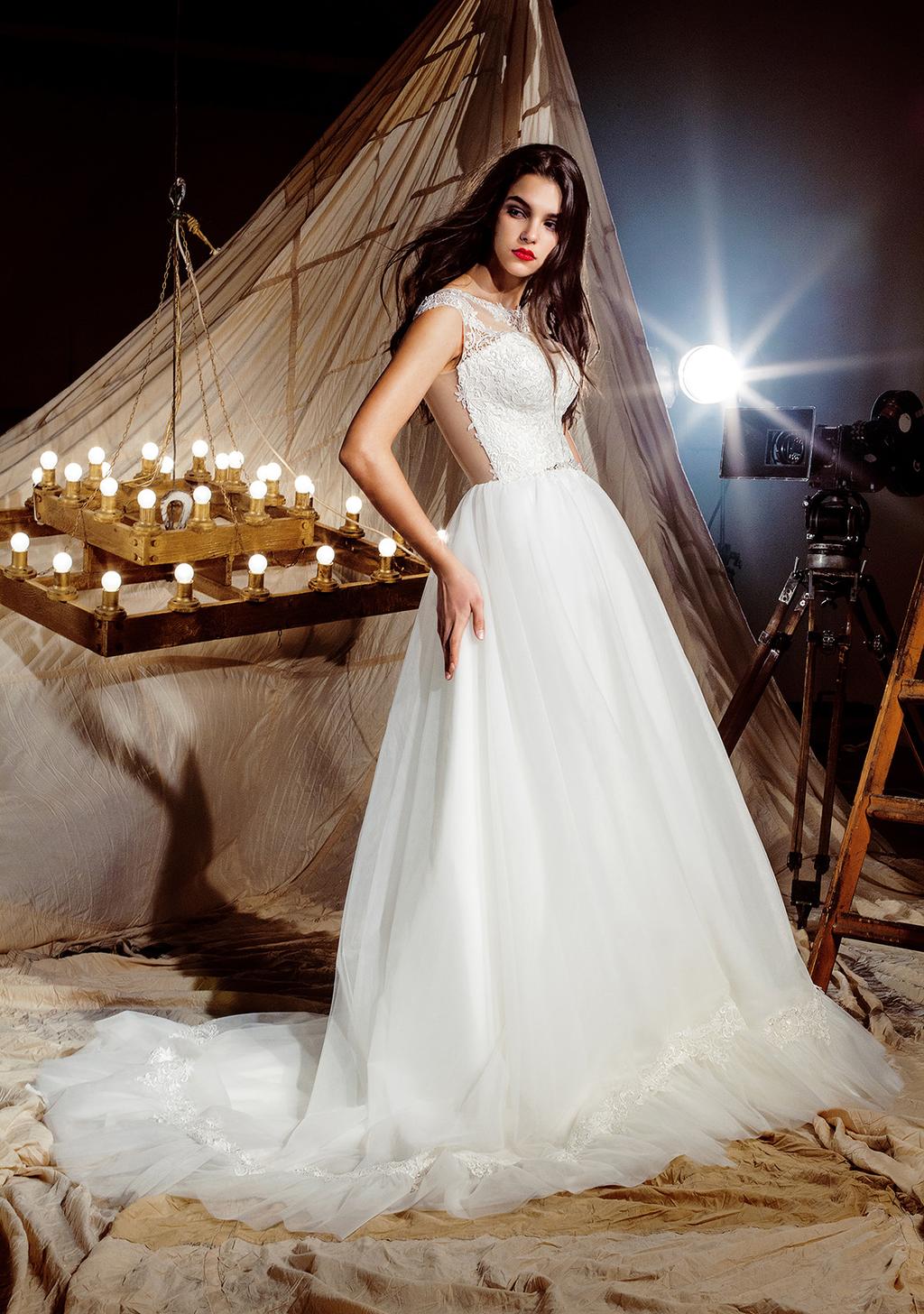 Tina Wholesale price: $315 Exquisite wedding dress with fluffy skirts. Light border of lace macrame forms ruffles along the bottom of tulle skirts.
