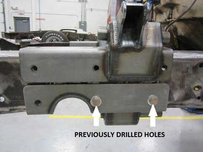 Place the cross member inside the frame rails close to the holes you previously drilled.