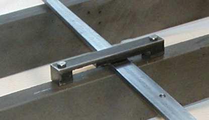 The lever pivot is installed on the sloped part of a frame channel which makes the idle orientation of the lever to be sloped downward. The strap holds the lever up and roughly level.