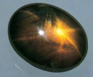 inclusions responsible for the asterism were a considerable distance from the surface, so that perhaps 2 mm of deep yellow-brown transparent sapphire covered the star-causing inclusions.