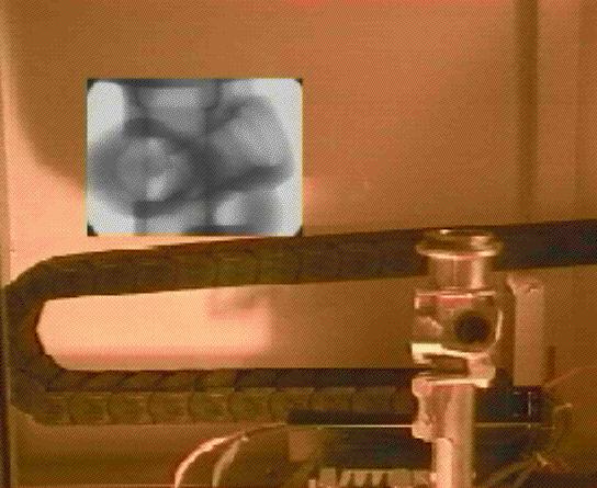 Figure 23 presents a view inside a radiation protection cabinet, where a steering housing is mounted on the manipulator. In the upper left corner a radiographic image is included.