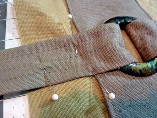 10. Repeat to attach the LONG handle strap around the grommet on the back panel. 11.