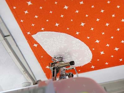 Spray the backside of the applique piece with temporary adhesive, and