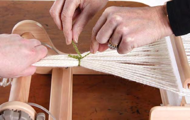 Look behind the reed and gently pull the left hand thread out of the slot. The other thread stays in the slot.