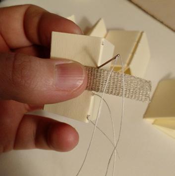 (3). Lay your piece of linen tape against the center of the signature s spine.