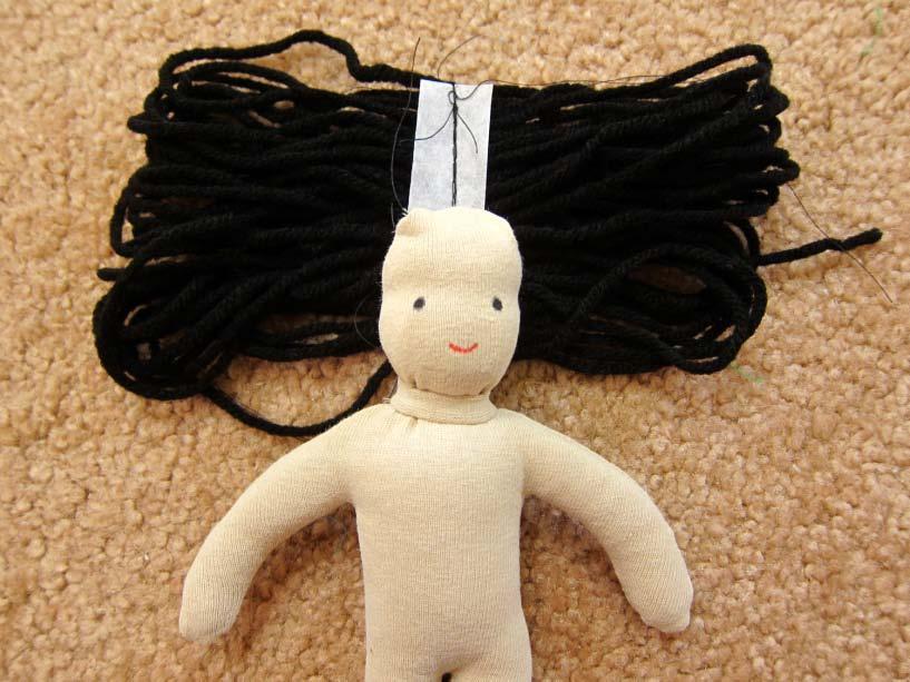 Cut a half inch strip of tear away stabilizer to fit the doll's scalp.