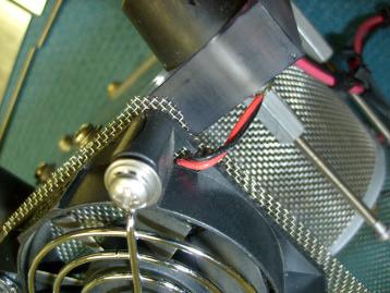 fan. Tighten the screws holding the fan, clamping the mesh between the