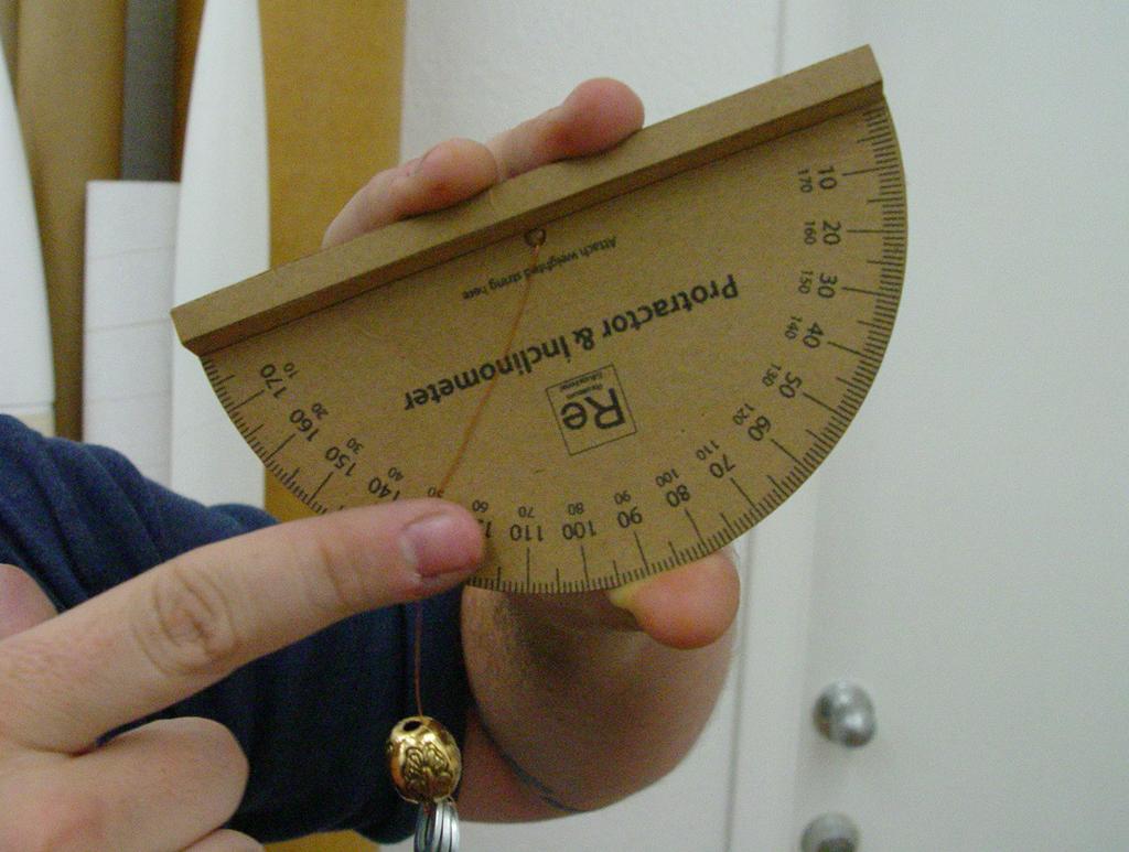 Practice pinching the string a few times, until you can do it without changing the angle. The string crossing the protractor marks the angle of the tilt of the inclinometer.