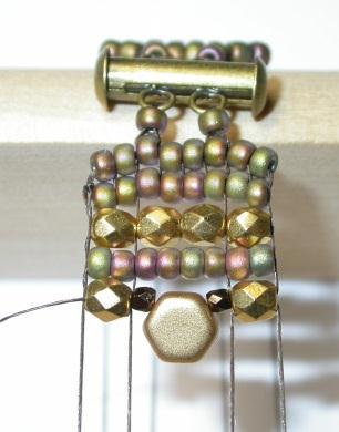 Press upwards on the beads and pass the needle back through the seed beads taking care