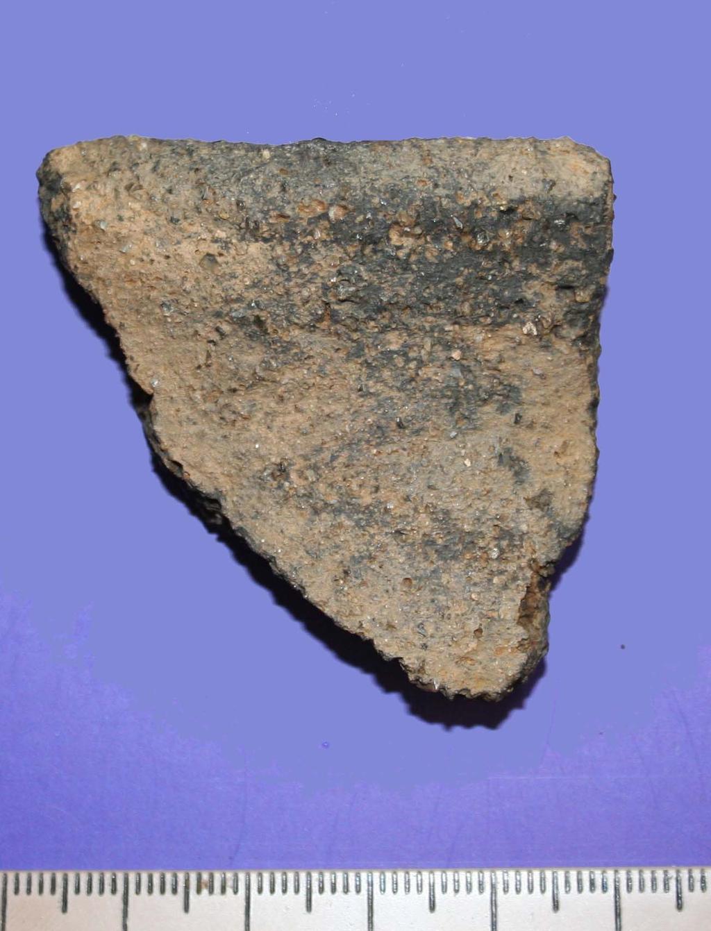 Vessel 4 A body sherd of coarse pottery. This sherd is 4mm thick and is light orange-brown. It has what appear to be crushed flint and mica inclusions.