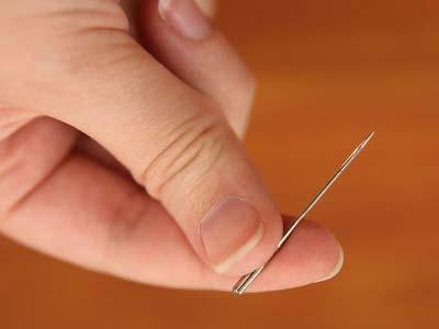 Use a size 11 sharp sewing needle in the machine rather than an
