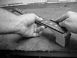Using a 6" or 8" smooth mill Bastard file, file the ends of the frets smooth.