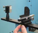 The knife edge/flat mirror assembly has two positional adjustments: moving