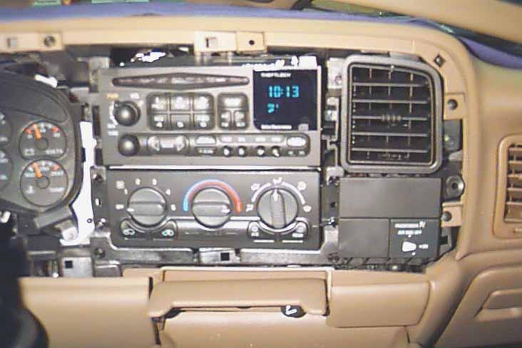 Pushing the lever/arm down will free the clips and the radio can be pulled from the dash. STEP 6: When the radio is pulled from the dash, unplug the antenna cable from the rear of the radio.