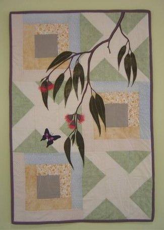 " At Home Among the Gum Trees " This striking quilted wallhanging has a background of two different blocks a Courthouse Steps block and a Triangle block arranged alternatively.