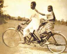 innovator in 1954. The direction of this rickshaw is controlled by a handle attached to the front wheel.