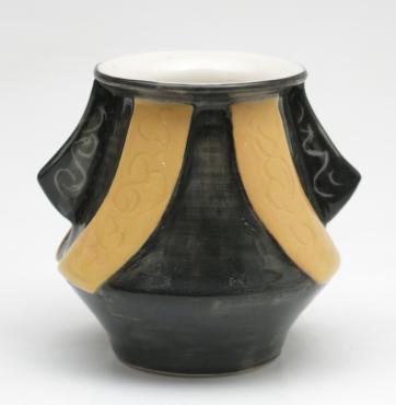 carved with applied, light to medium orange Translucent Porcelain blends and black slip, both with sgraffitoed patterns. Clear glaze overall.