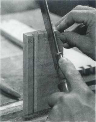 15 Carefully (to avoid splitting the drawer front), shape the sides of the pins with the chisel.