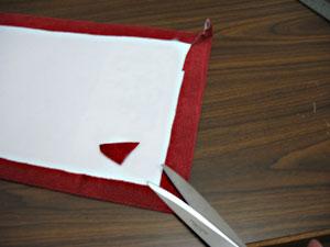 Spray the wrong side of the fabric with adhesive, wrap the edges of the fabric over, and press in place pinch each corner