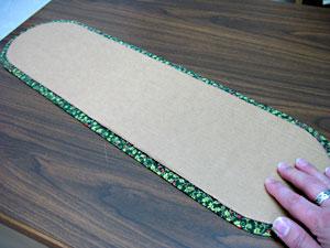 Spray the wrong side of the fabric piece with adhesive.
