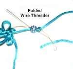 Fold a piece of thin wire in half to make a threader. Pass it through the hole in the bead, with the ends close to the butterfly.