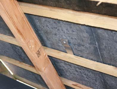 Slide the brackets (item 0) into the gap so that the cranked part drops over the top edge of the slate into the roof space.