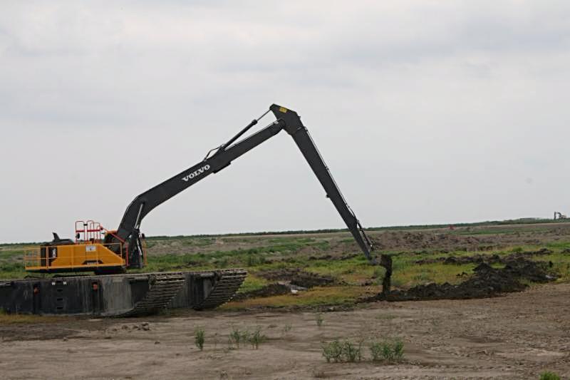 A pontoon excavator creating a tidal channel Transforming Cell 5AB into a wetland first involves grading, or leveling, the land.