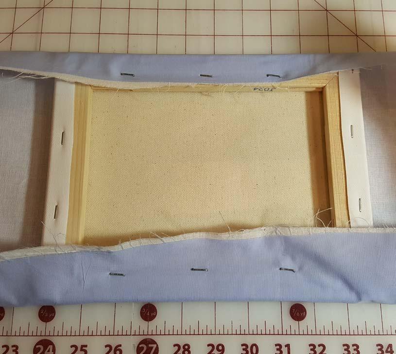 Check the front and pull to smooth any wrinkles. Staple other two sides. Fold in and trim bulk at the corners and staple in place.