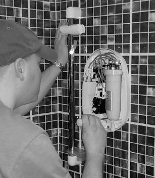 Q1.An electrician is replacing an old electric shower with a new one. The inside of the old shower is shown in Figure 1.