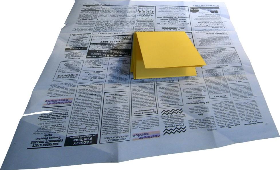 While folding the newspaper, simply turn over the yellow paper. The large side of the newspaper will help to cover this move.