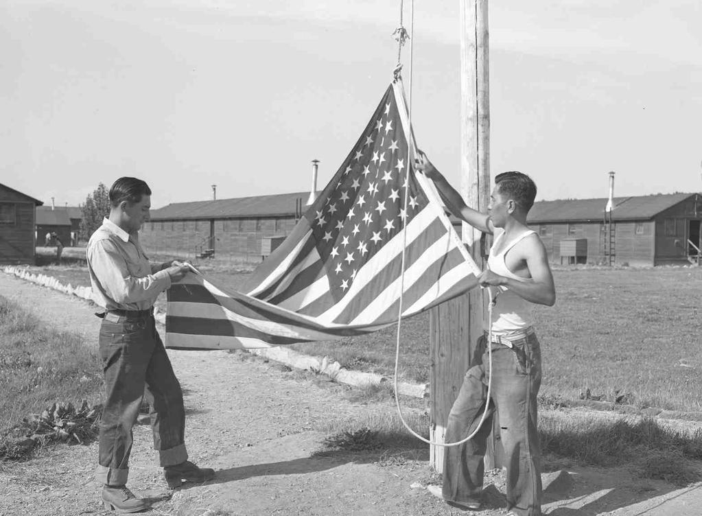 OCHC Lee #009 Japanese Americans taking down the flag near Rupert, Idaho. Rupert, Idaho. Former Civilian Conservation Corps camp now under Farm Security Administration management.