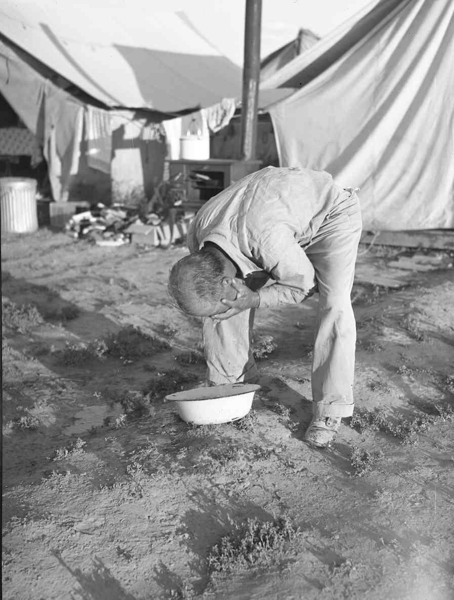 OCHC Lee #012 Japanese American washing his face at the Garrison s Corner camp near Nyssa, Oregon.