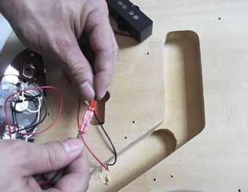 Gently thread the red cable (connector lead, with connector) through the hole behind the tone control cavity to the separate