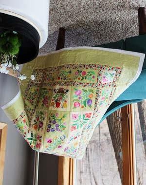 A lap quilt blooming with a whole garden of colorful blossoms brings home