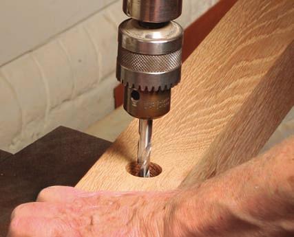 Make room for the bed bolts. Cut the wide mortise first, then drill a 1 16-in.-dia. through-hole at the center (top). Turn the post over and use a 1-in. Forstner bit to drill a 3 4-in.