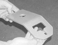 ) Then attach a tie down chain to the tie back bracket and use a turnbuckle assist to support the anchoring assembly.