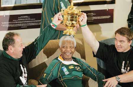 Former South African President Nelson Mandela poses with South African Rugby Union coach Jake White and Springbok captain John Smit.