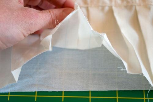 Pin the corners to the interfacing panel first, aligning the straight tucks.