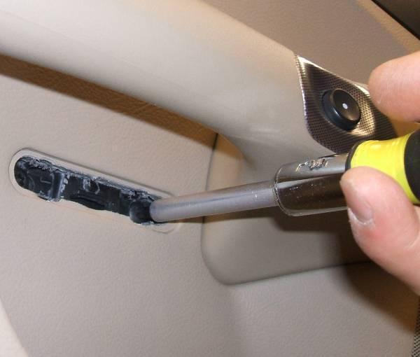 Remove the (2) screws behind door handle using a T-15 Torx wrench. 3.