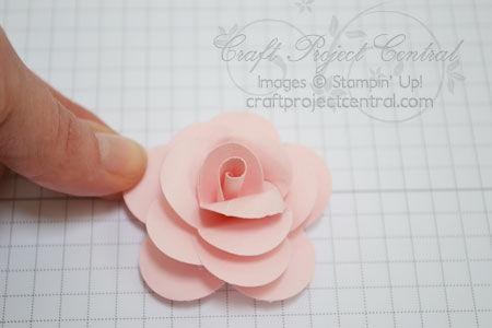 Use hot glue to glue the rose in place. Hold the rose in place until the glue dries.