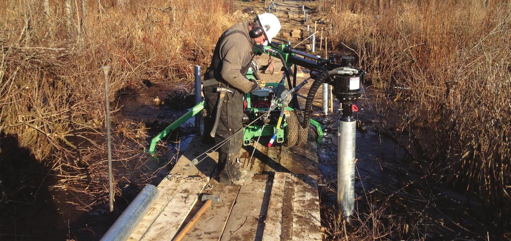 Figure 1. A worker from Techno Metal Post of Albany installs one of the helical piles that were used to support the boardwalk framing in the sensitive wetlands.