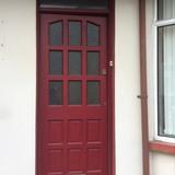 The front door is solid wood painted red with