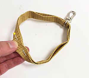 Thread the strap through the loop of the swivel hook. Insert the raw end of the loop in between the folds of the folded short end.