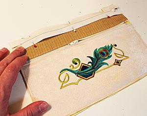 For the back fabric of the wristlet, align the front portion on top of the fabric, pin in place, and cut out the shape.