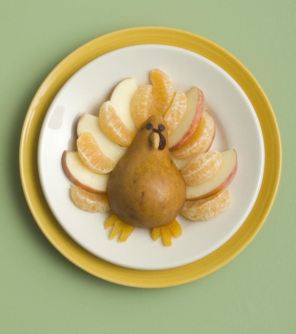Use scissors to halve a dried apricot, then snip small triangles from each half and tuck them under the pear to form the feet.