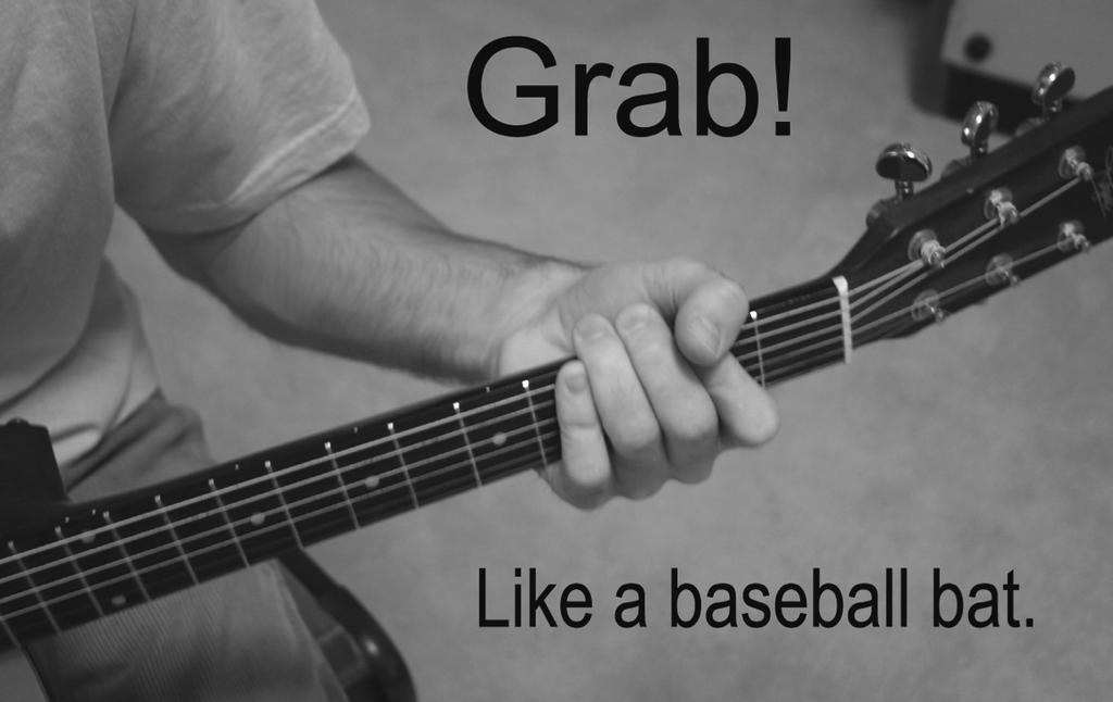 Grab! Now grab the neck just like a baseball bat. Your thumb should be hanging over the neck and your fingers on the fret board.